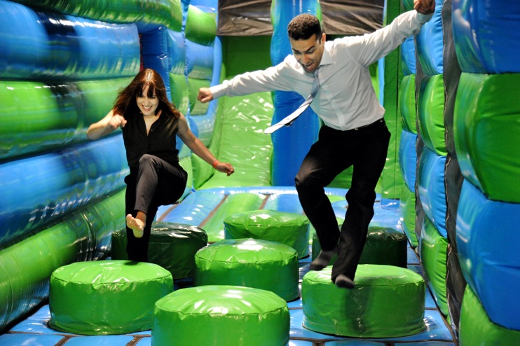 Two colleagues racing through an inflatable obstacle course.